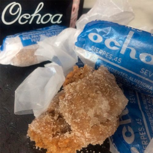 Alfajores tradicionales cubiertos de azúcar y parcialmente envueltos en papel azul distintivo de la Confitería Ochoa, situada en la céntrica calle Sierpes en Sevilla.
